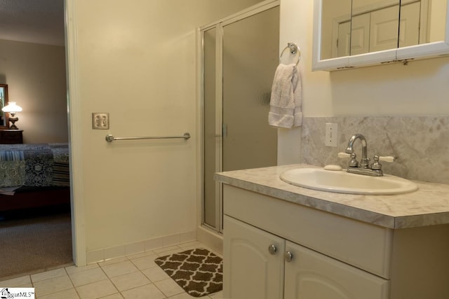 bathroom with ensuite bathroom, tile patterned flooring, a shower stall, vanity, and tasteful backsplash