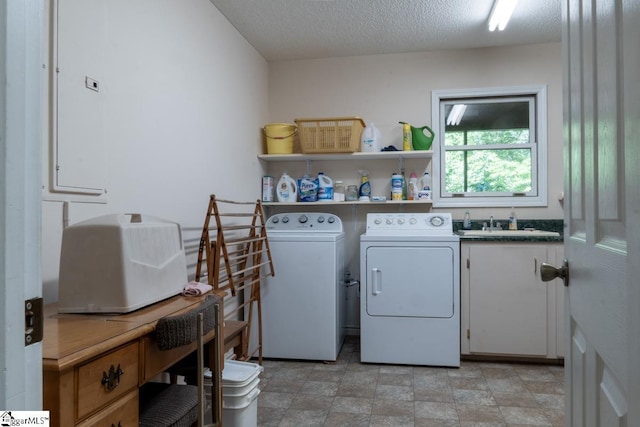 laundry room featuring independent washer and dryer, cabinet space, a textured ceiling, and stone finish flooring