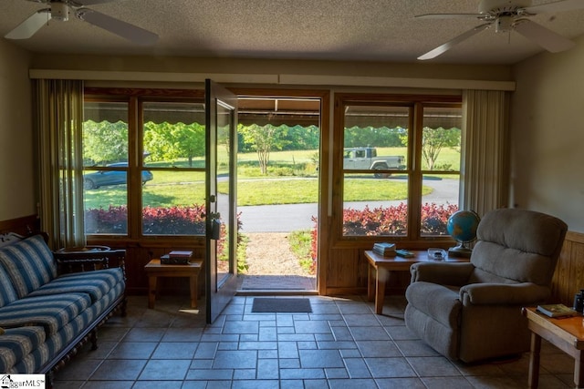 doorway to outside featuring a ceiling fan, a textured ceiling, and stone finish flooring