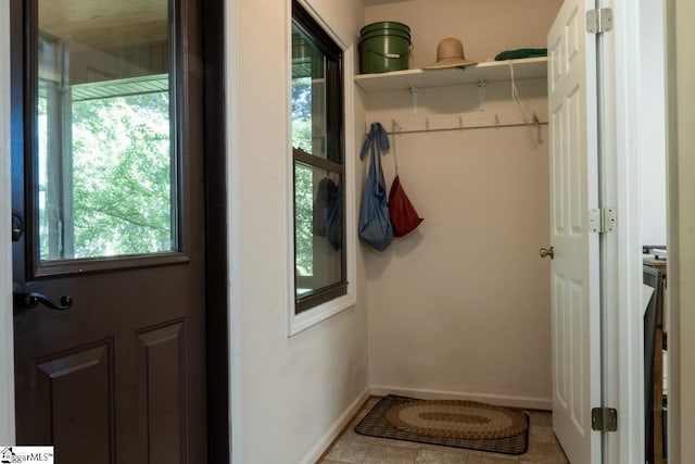 doorway featuring healthy amount of natural light, baseboards, and tile patterned floors