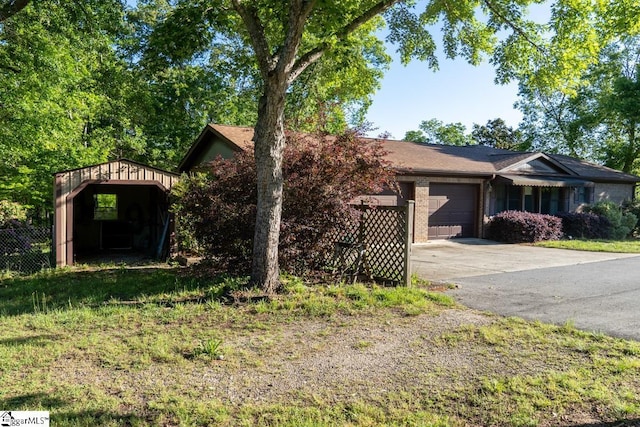 view of front of home with an attached garage, concrete driveway, fence, and brick siding