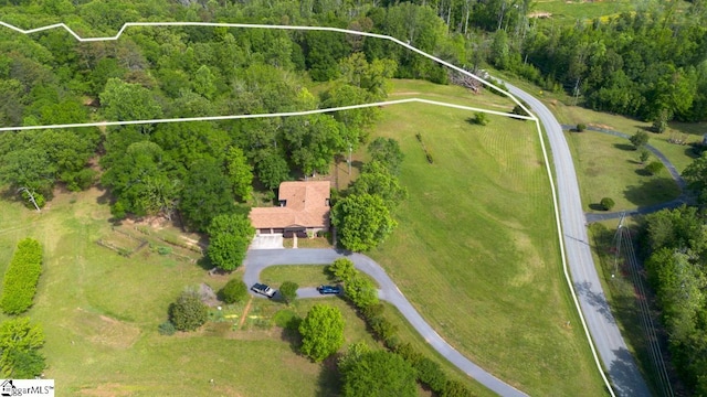 aerial overview of property's location with property boundaries highlighted and a heavily wooded area