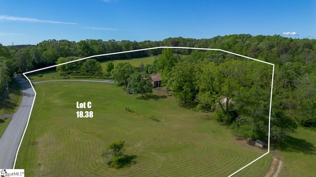 aerial view of property and surrounding area with property parcel outlined and a forest