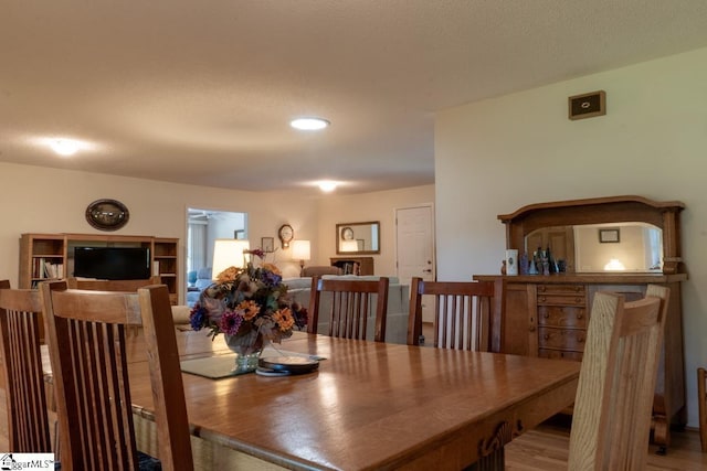 dining area with wood finished floors and recessed lighting