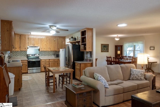 living area with ceiling fan, light floors, and recessed lighting
