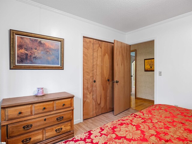 132 Rosecrest Rd, Spartanburg, SC 29303 - bedroom with light wood-style flooring, crown molding, a closet, a textured ceiling, and baseboards