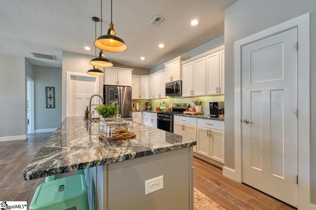 2007 Edwards Lake Rd, Greer, SC 29651 - kitchen with stainless steel appliances, white cabinets, light wood-style floors, backsplash, and recessed lighting