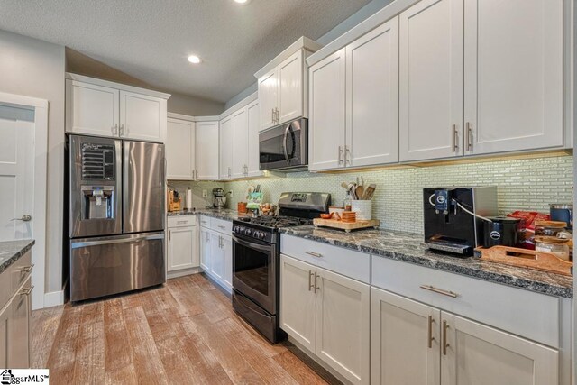 2007 Edwards Lake Rd, Greer, SC 29651 - kitchen featuring appliances with stainless steel finishes, light wood-type flooring, white cabinetry, dark stone countertops, and recessed lighting