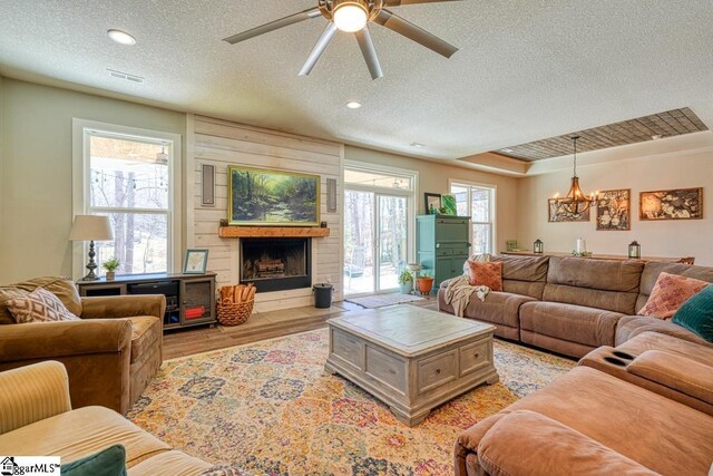 2007 Edwards Lake Rd, Greer, SC 29651 - living room featuring a textured ceiling, light wood-style flooring, ceiling fan, a fireplace, and a chandelier