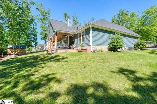 2007 Edwards Lake Rd, Greer, SC 29651 - back of property featuring ceiling fan, a chimney, central air condition unit, a lawn, and a shingled roof