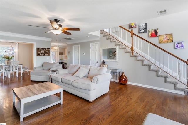 living area featuring stairway, ornamental molding, a ceiling fan, baseboards, and a chandelier