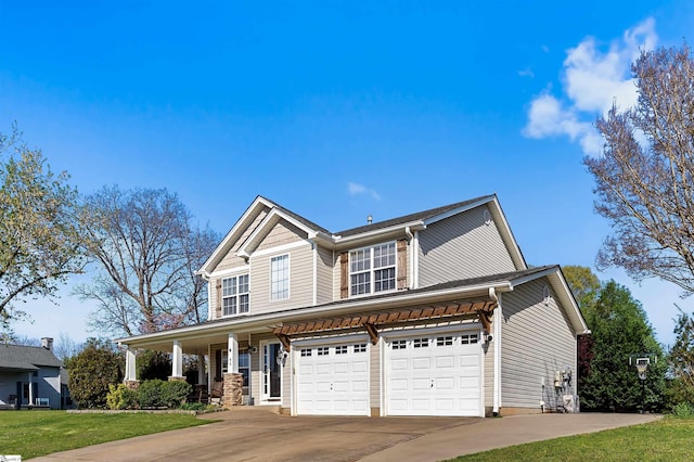 traditional-style home featuring a garage, covered porch, driveway, and a front yard