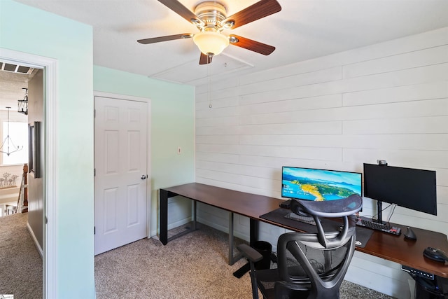office area with ceiling fan, carpet flooring, and wooden walls
