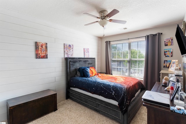 bedroom featuring light colored carpet, a textured ceiling, and ceiling fan