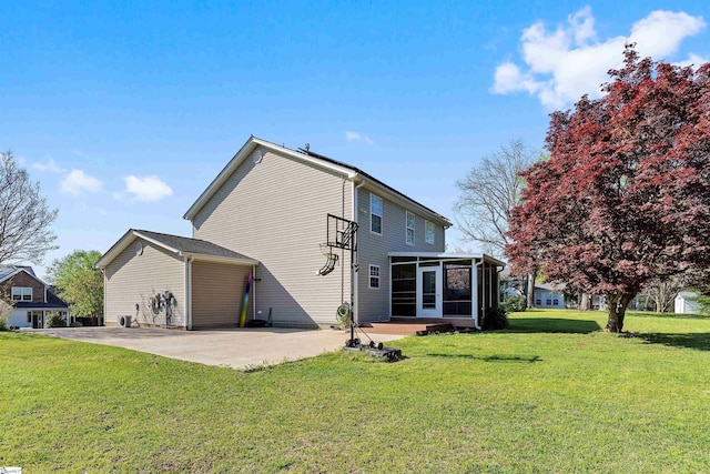 rear view of house featuring a sunroom, a yard, and a patio