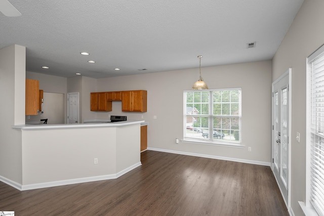 kitchen with brown cabinets, dark wood-type flooring, baseboards, recessed lighting, and light countertops