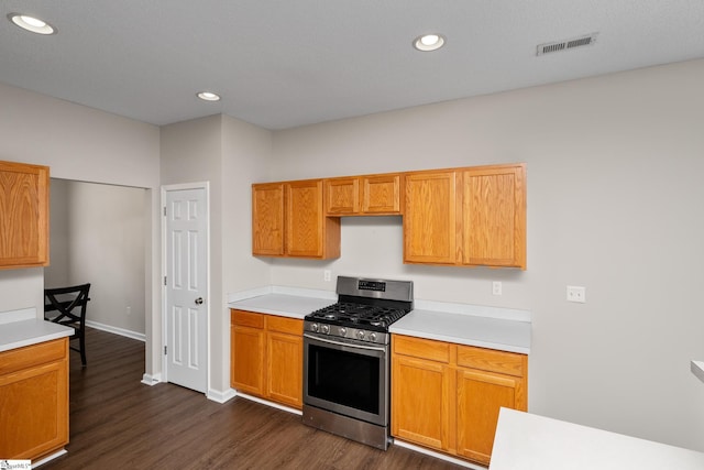 kitchen with gas range, light countertops, dark wood finished floors, baseboards, and recessed lighting