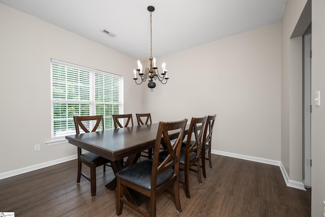 dining space featuring wood finished floors, a chandelier, and baseboards