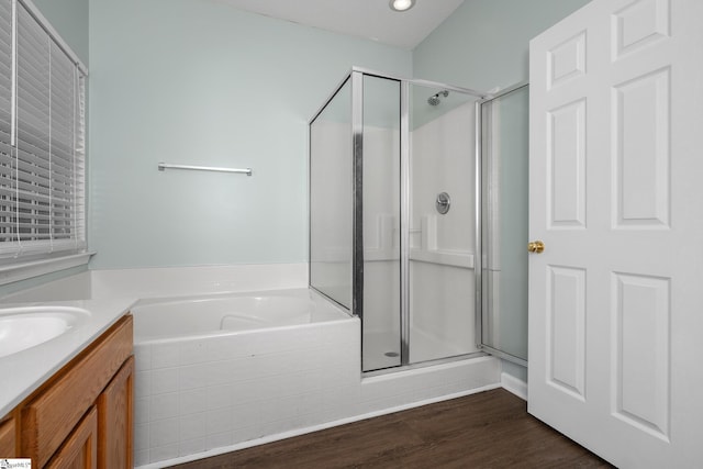 bathroom featuring a shower stall, vanity, a garden tub, wood finished floors, and recessed lighting