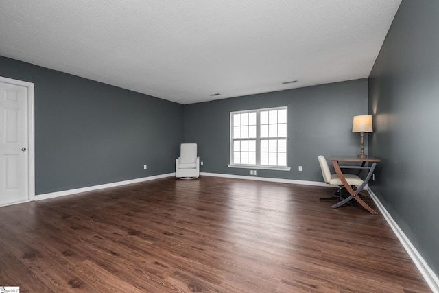 unfurnished office featuring wood finished floors and baseboards
