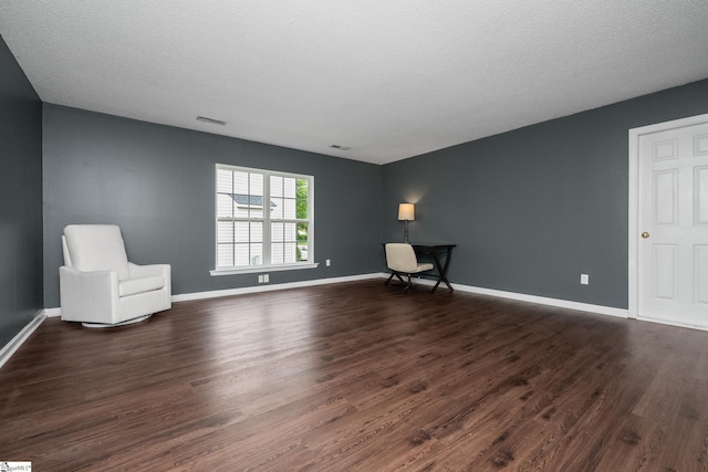 unfurnished room with dark wood-style flooring and baseboards