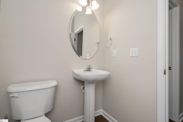 half bathroom featuring toilet and baseboards