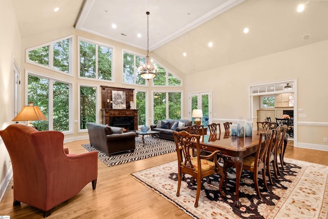 201 King Eider Way, Taylors, SC 29687 - dining room featuring a lit fireplace, healthy amount of natural light, high vaulted ceiling, and light wood finished floors