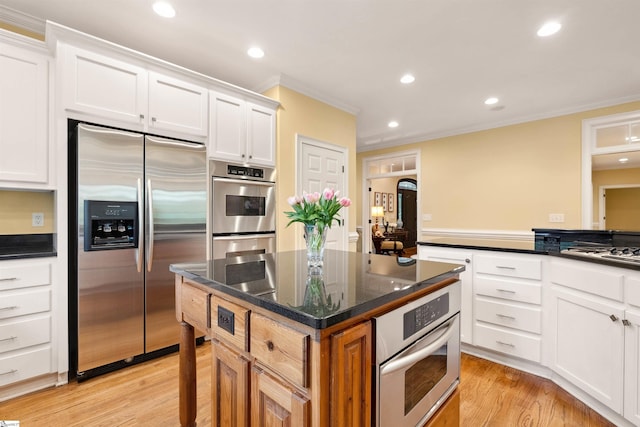 201 King Eider Way, Taylors, SC 29687 - kitchen featuring appliances with stainless steel finishes, a kitchen island, white cabinetry, crown molding, and light wood finished floors