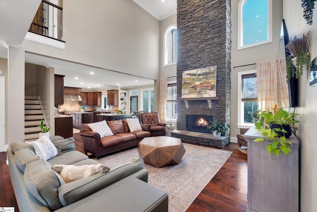 100 Bent Willow Way, Easley, SC 29642 - living room featuring a towering ceiling, stairway, dark wood finished floors, a stone fireplace, and ornamental molding