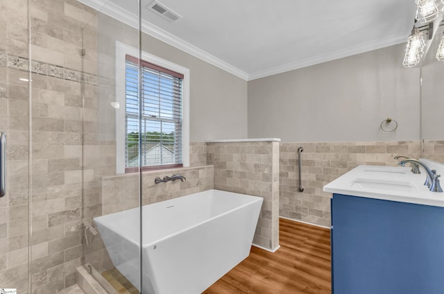 130 Windjammer Way, Anderson, SC 29626 - bathroom featuring tile walls, crown molding, wood finished floors, a soaking tub, and double vanity