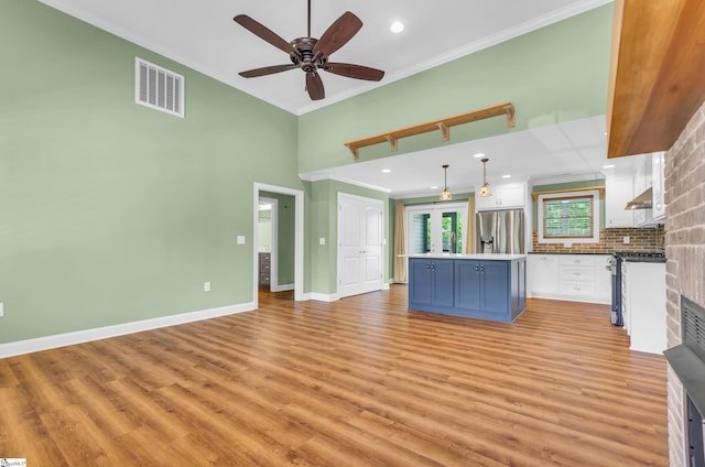 130 Windjammer Way, Anderson, SC 29626 - kitchen featuring appliances with stainless steel finishes, ornamental molding, white cabinets, light wood-style floors, and a center island