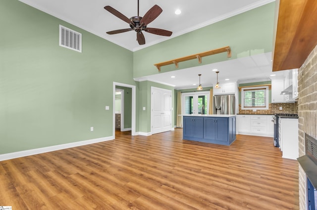 130 Windjammer Way, Anderson, SC 29626 - kitchen with appliances with stainless steel finishes, crown molding, white cabinets, a kitchen island, and light wood finished floors