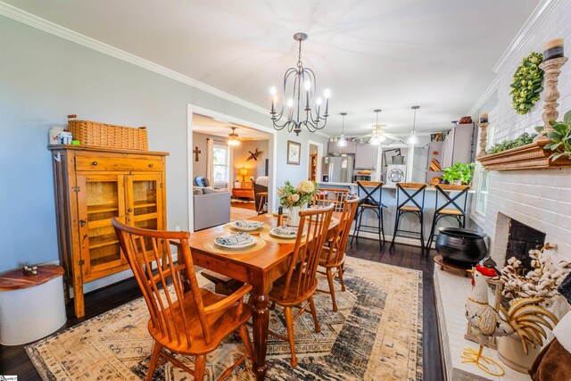 147 Daniel Dr, Easley, SC 29642 - dining room featuring a ceiling fan, wood finished floors, a chandelier, crown molding, and a fireplace