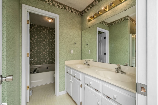 bathroom featuring tile patterned flooring, toilet, double vanity, a tub, and baseboards