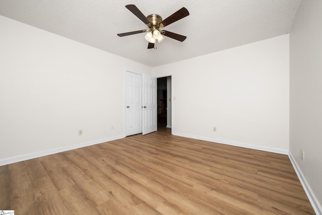 spare room with light wood finished floors, baseboards, and a ceiling fan