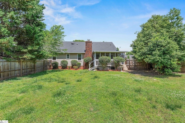 rear view of property with a sunroom and a chimney