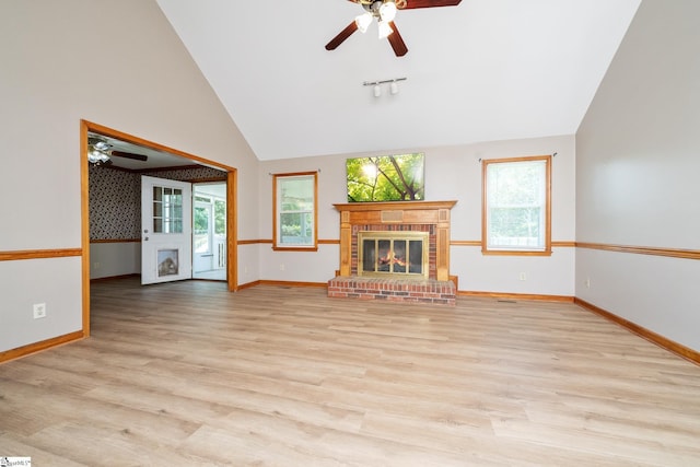 unfurnished living room with a ceiling fan, lofted ceiling, light wood-style floors, and a brick fireplace
