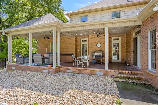 back of house with ceiling fan, a patio, roof with shingles, and brick siding