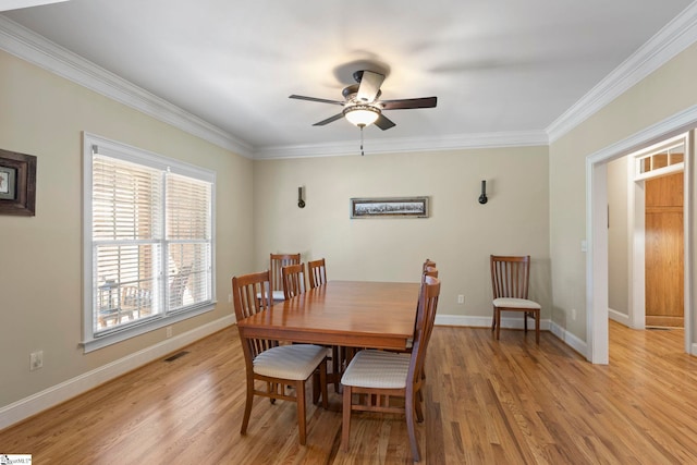 dining room featuring ceiling fan, crown molding, light wood-type flooring, and baseboards