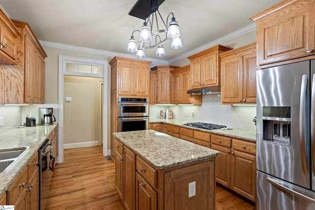 kitchen featuring stainless steel appliances, under cabinet range hood, wood finished floors, a kitchen island, and backsplash