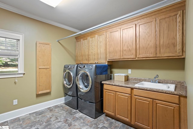 clothes washing area with cabinet space, washing machine and dryer, ornamental molding, baseboards, and stone finish floors