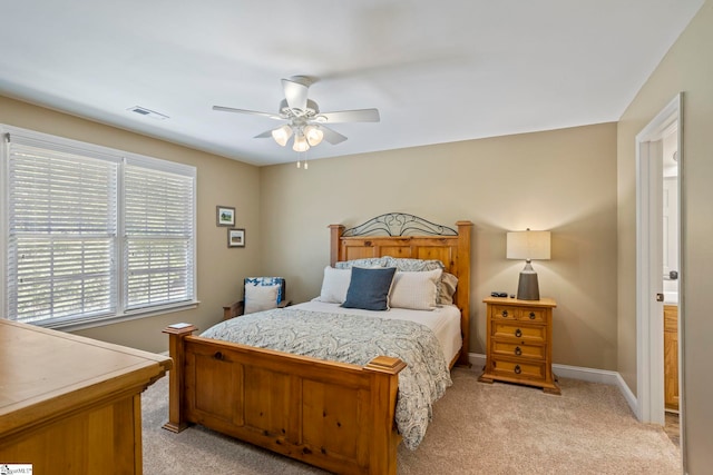 bedroom featuring light colored carpet, baseboards, and a ceiling fan