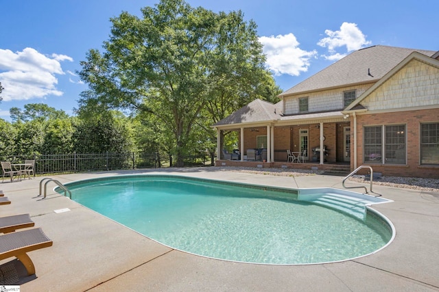 view of pool with a patio area and fence