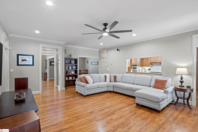 living area featuring a ceiling fan, recessed lighting, light wood finished floors, ornamental molding, and baseboards