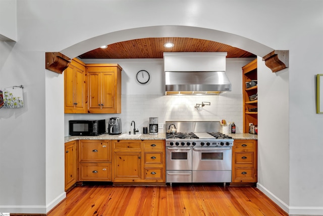 kitchen with range with two ovens, a sink, black microwave, wooden ceiling, and light wood-type flooring