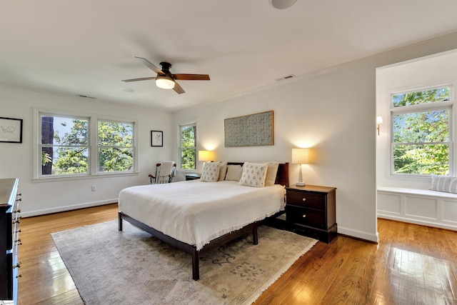bedroom featuring light wood finished floors, baseboards, and a ceiling fan