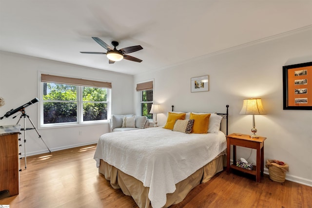 bedroom with baseboards, light wood finished floors, a ceiling fan, and ornamental molding