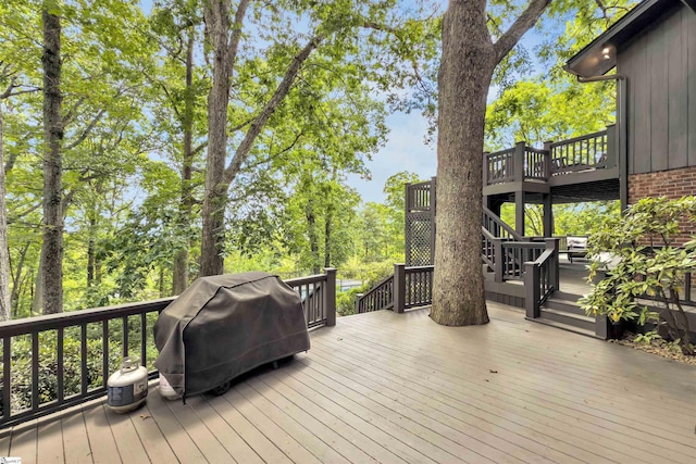 wooden deck featuring area for grilling and stairway