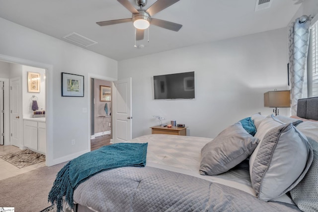 bedroom featuring light carpet, connected bathroom, and ceiling fan
