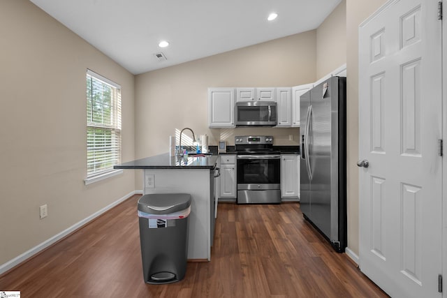 113 Glastonbury Dr, Greer, SC 29651 - kitchen with appliances with stainless steel finishes, a peninsula, white cabinets, dark countertops, and vaulted ceiling